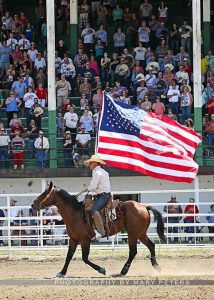 Horse Rider carrying USA flag at the start of a Rodeo