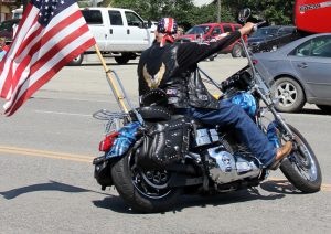Motorcycle rider at the 4th July Parade with flag a Link to the Visitors page